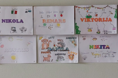Siena ar bērnu veidotiem plakātiem kur veidotāja vārds ir vidū un dažādiem objektiem  ar viņu nosaukumiem  vācu valodā.