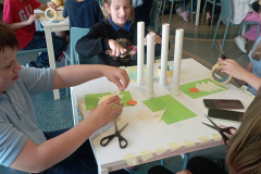 Bērni veido paprīra raķetītes.