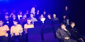 8. klases skolnieki sēz kino teātrī un skatās prezentāciju