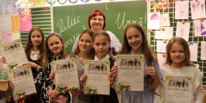 3.c klases skolnieki ar skolotāju rāda savus Atzinībus rakstus