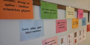 Siena ar plakātiem uz kuriem ir motivējoši teksti