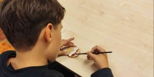 Bērns krāso koka ripu