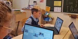 bērni strādā pie klēpjdatoriem klasē