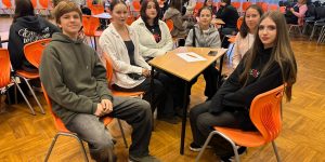 Skolēni sēž pie galda