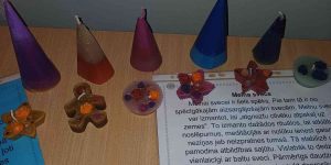 Paštiasītas svecītes konusa, piparkūku vīriņa un zvaigznītes formā uz galda stāv.