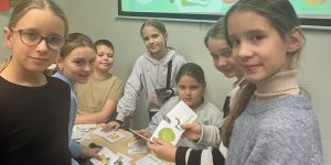 Skolēni pie galda liek puzli