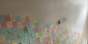 Papīršī ar dzejoļiem pilīmēti uz sienas kāpņu telpā