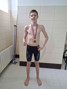 Damirs Lebedzevs 3. vietas ieguvējs peldēšanas sacensībās ar savu medaļu