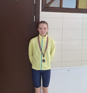 Emilija Karcevska 2. vietas ieguvejs peldēšanas sacensībās ar savu medaļu