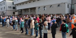 Visa skola pagalmā atkārto sporta kustības muzikas ritmā