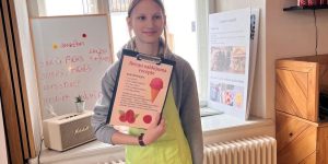 Meitene stāv ar aveņu saldējuma recepti rokās