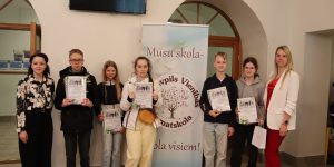 Direktore ar šī gada Diplomu ieguvējiem pie skolas logo kopbilde
